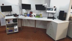 Stanowisko serwisowe powerON w 2020 roku z biurkiem, monitorami i sprzętem komputerowym.