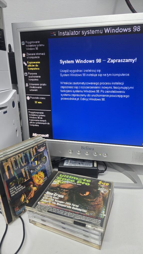Ekran instalatora Windows 98 na monitorze CRT Belinea, obok kolekcja klasycznych gier komputerowych na płytach CD