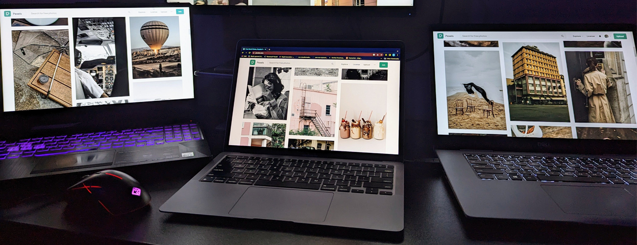 Trzy laptopy ustawione na biurku z otwartymi stronami internetowymi – przykładowy sprzęt do pracy i szkoleń.