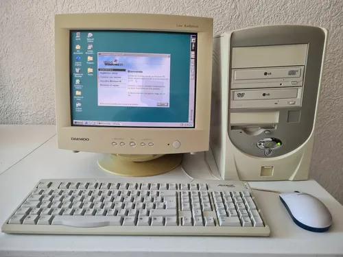 Beżowy komputer stacjonarny z monitorem CRT, klawiaturą i myszką, charakterystyczny dla przełomu lat 90. i 2000.
